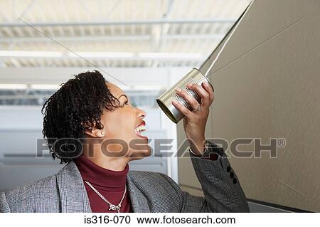 Stock Image - Woman using a tin can telephone. Fotosearch