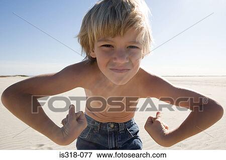 Boy flexing muscles on beach View Large Photo Image Stock Photo - Boy flexing muscles on beach. Fotosearch