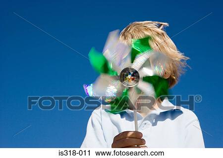 Stock Image - Boy holding pinwheel in front of face. Fotosearch