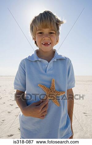 Stock Photo - Boy holding starfish. Fotosearch