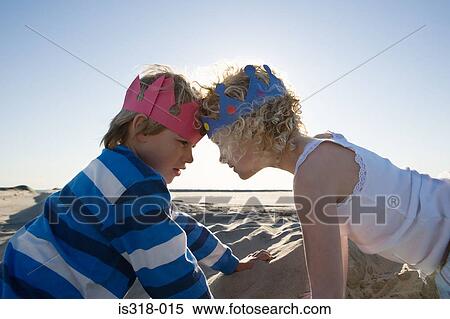 Stock Photography - Brother and sister wearing crowns forehead to forehead. Fotosearch