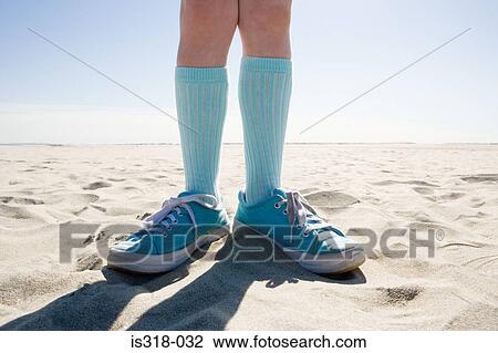 Stock Image - Child standing on beach. Fotosearch