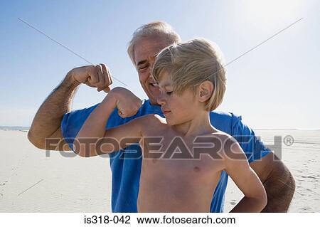 Grandfather and grandson flexing biceps on beach View Large Photo Image Stock Image - Grandfather and grandson flexing biceps on beach. Fotosearch