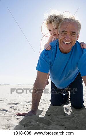 Grandfather playing with granddaughter on beach View Large Photo Image Stock Photo - Grandfather playing with granddaughter on beach. Fotosearch