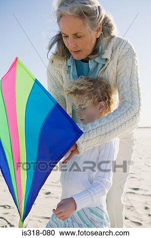Grandmother and granddaughter playing with kite on beach View Large Photo Image Stock Image - Grandmother and granddaughter playing with kite on beach. Fotosearch