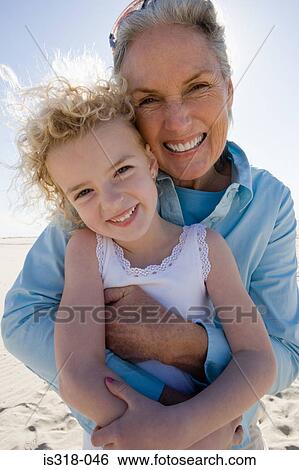 Stock Photograph - Grandmother and granddaughter posing on beach. Fotosearch