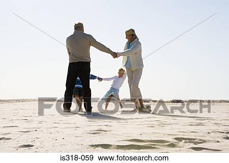 Grandparents dancing with grandchildren on beach View Large Photo Image Stock Photo - Grandparents dancing with grandchildren on beach. Fotosearch