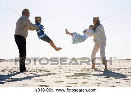 Grandparents playing with grandchildren on beach View Large Photo Image Stock Photography - Grandparents playing with grandchildren on beach. Fotosearch
