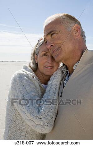 Stock Photo - Senior couple hugging on beach. Fotosearch