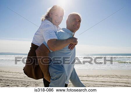 Senior man carrying woman on back View Large Photo Image Stock Photograph - Senior man carrying woman on back. Fotosearch