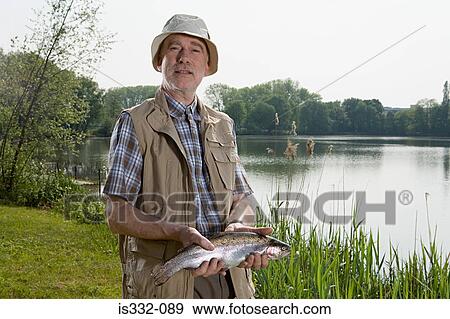 Stock Photo - Angler holding a fish. Fotosearch