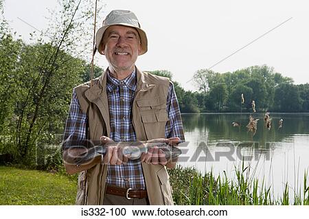 Stock Image - Angler holding fish. Fotosearch
