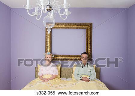 Stock Photography - Couple in bed looking miserable. Fotosearch