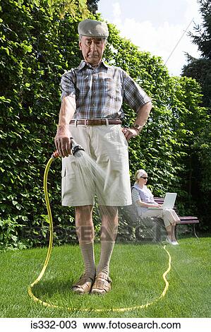 Man watering lawn View Large Photo Image Stock Image - Man watering lawn. Fotosearch