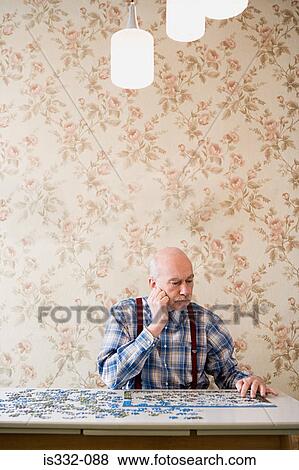 Stock Photo - Man with a jigsaw puzzle. Fotosearch