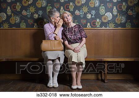 Senior woman whispering to friend View Large Photo Image Stock Photo - Senior woman whispering to friend. Fotosearch