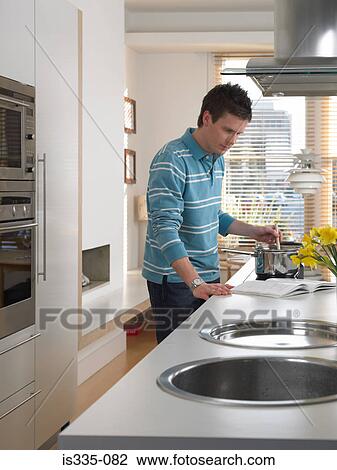 Stock Image - Man cooking in kitchen. Fotosearch