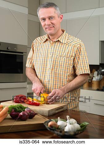 Man cutting vegetables in kitchen View Large Photo Image Picture - Man cutting vegetables in kitchen. Fotosearch
