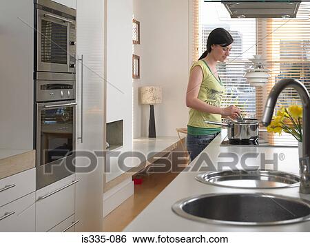 Stock Photograph - Woman cooking in kitchen. Fotosearch