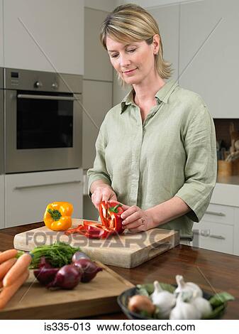 Woman cutting bell peppers View Large Photo Image Stock Image - Woman cutting bell peppers. Fotosearch