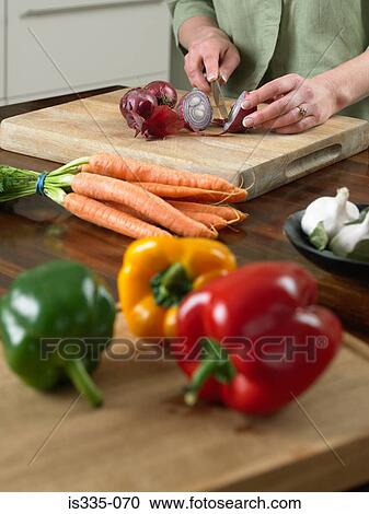 Stock Image - Woman cutting vegetables. Fotosearch