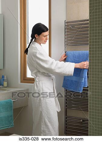 Woman holding towels in bathroom View Large Photo Image Stock Photo - Woman holding towels in bathroom. Fotosearch