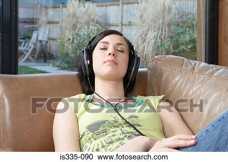 Woman listening to music on sofa View Large Photo Image Stock Image - Woman listening to music on sofa. Fotosearch