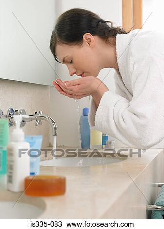 Stock Image - Woman washing her face. Fotosearch
