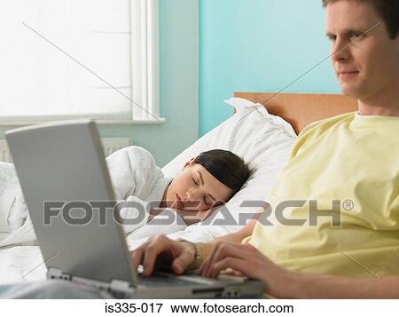 Stock Photo - Young couple resting in bed. Fotosearch