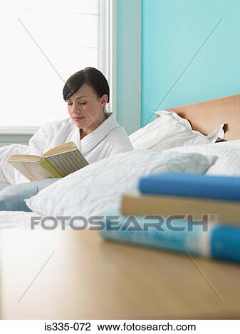 Young woman reading in bed View Large Photo Image Stock Image - Young woman reading in bed. Fotosearch