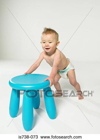 Baby with blue stool View Large Photo Image Stock Image - Baby with blue stool. Fotosearch
