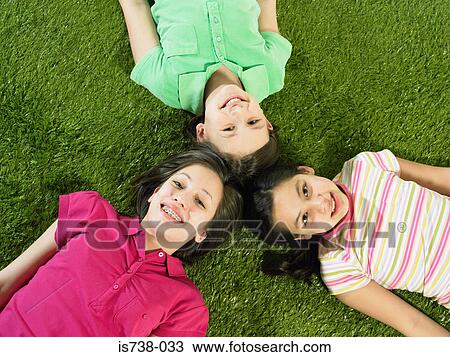 Friends lying on grass View Large Photo Image Stock Image - Friends lying on grass. Fotosearch