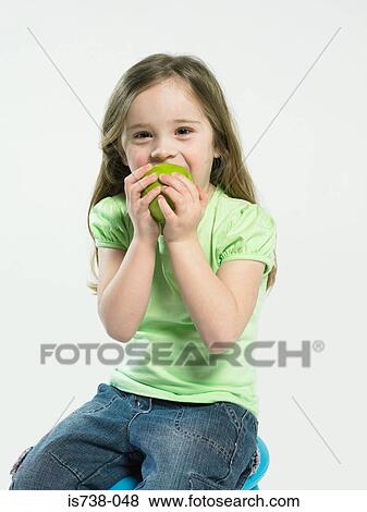 Girl eating an apple View Large Photo Image Stock Photo - Girl eating an apple. Fotosearch