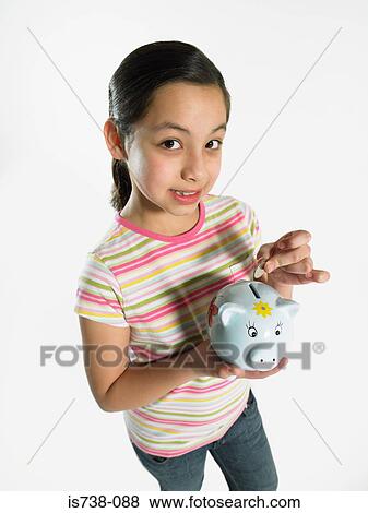 Girl putting money in piggy bank View Large Photo Image Stock Photo - Girl putting money in piggy bank. Fotosearch