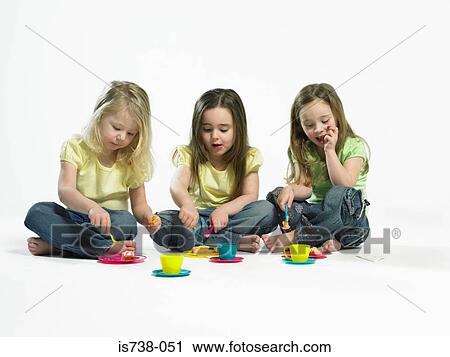 Stock Image - Three little girls having cake. Fotosearch