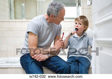 Stock Image - Boy and grandfather brushing teeth. Fotosearch