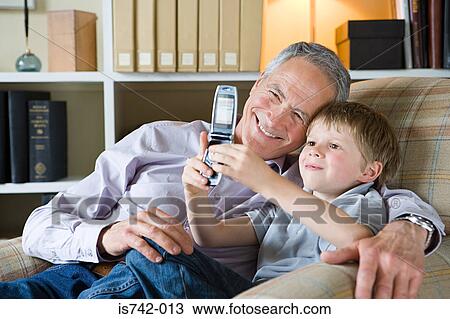 Stock Image - Boy and grandfather with camera phone. Fotosearch