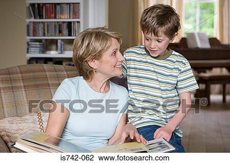 Boy and grandmother looking at scrapbook View Large Photo Image Stock Image - Boy and grandmother looking at scrapbook. Fotosearch