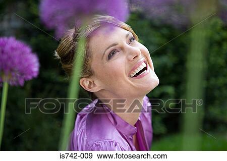 Carefree woman amongst allium flowers View Large Photo Image Stock Photo - Carefree woman amongst allium flowers. Fotosearch