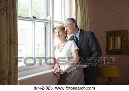 Stock Photography - Couple looking out of window. Fotosearch