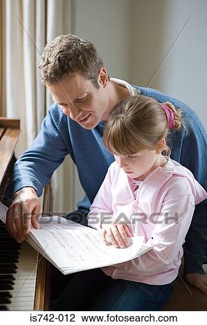 Father and daughter looking at sheet music View Large Photo Image Stock Image - Father and daughter looking at sheet music. Fotosearch