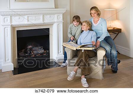 Female relatives looking at photograph album View Large Photo Image Stock Photo - Female relatives looking at photograph album. Fotosearch