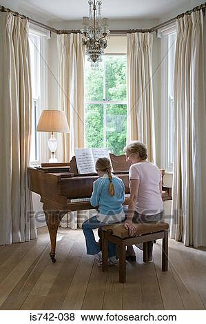 Stock Photo - Girl and grandmother playing piano. Fotosearch