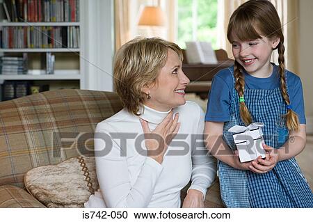 Stock Image - Girl giving present to grandmother. Fotosearch