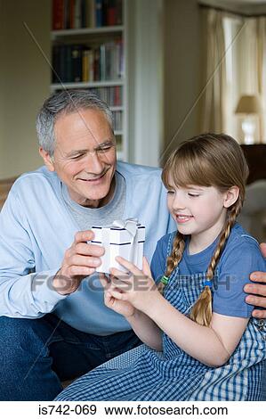 Stock Photo - Grandfather giving present to girl. Fotosearch