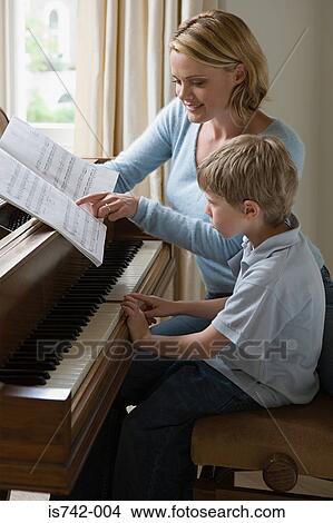 Picture - Mother teaching piano to son. Fotosearch