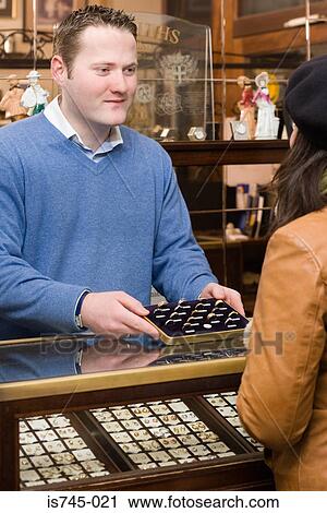 Stock Image - Jeweller serving customer. Fotosearch