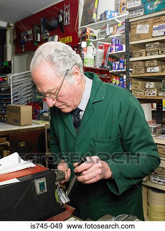 Stock Photo - Man cutting a key. Fotosearch