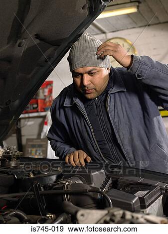 Mechanic working on an engine View Large Photo Image Stock Photo - Mechanic working on an engine. Fotosearch