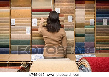 Stock Photography - Woman choosing carpet. Fotosearch